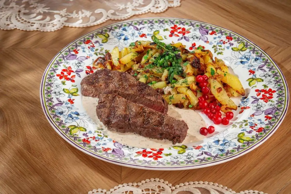 Вырезка теленка с перечным соусом, моченой брусникой и жареной картошкой
