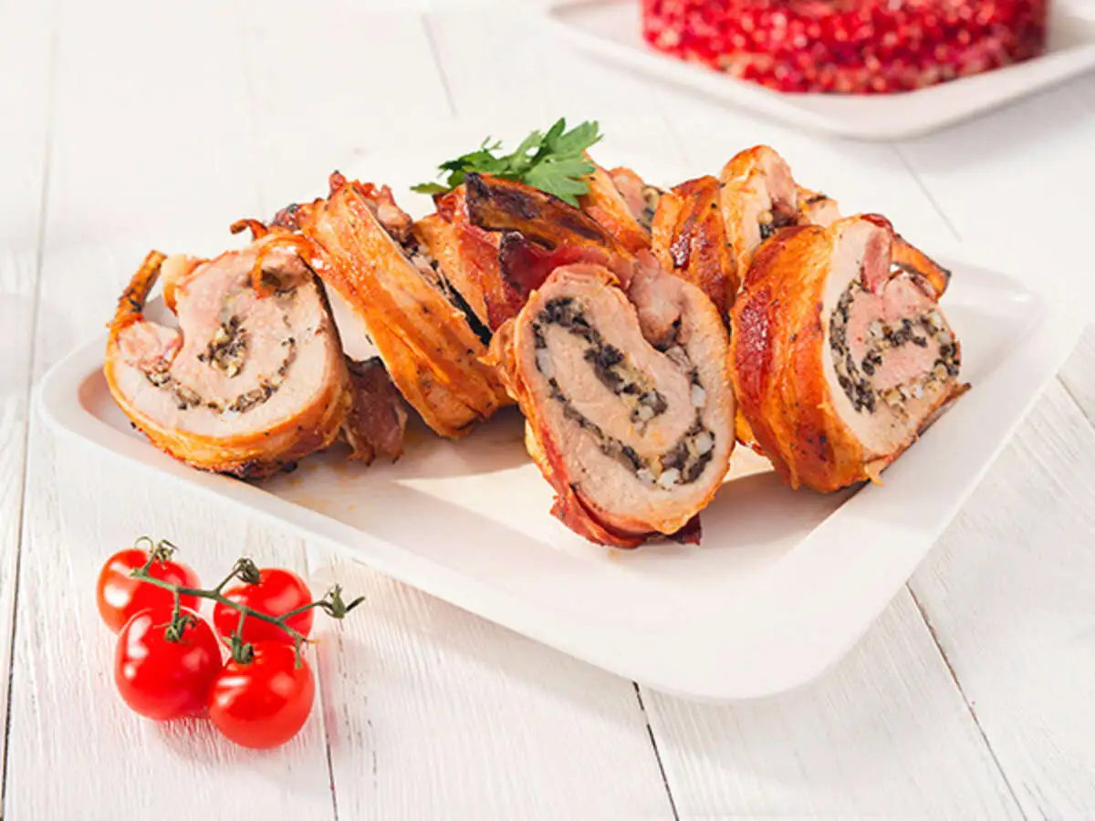 Фаршированная шампиньонами свиная корейка, запеченная в беконе